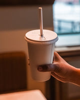 Grale Disposable 16oz Cup, Lifestyle with Straw and Lid